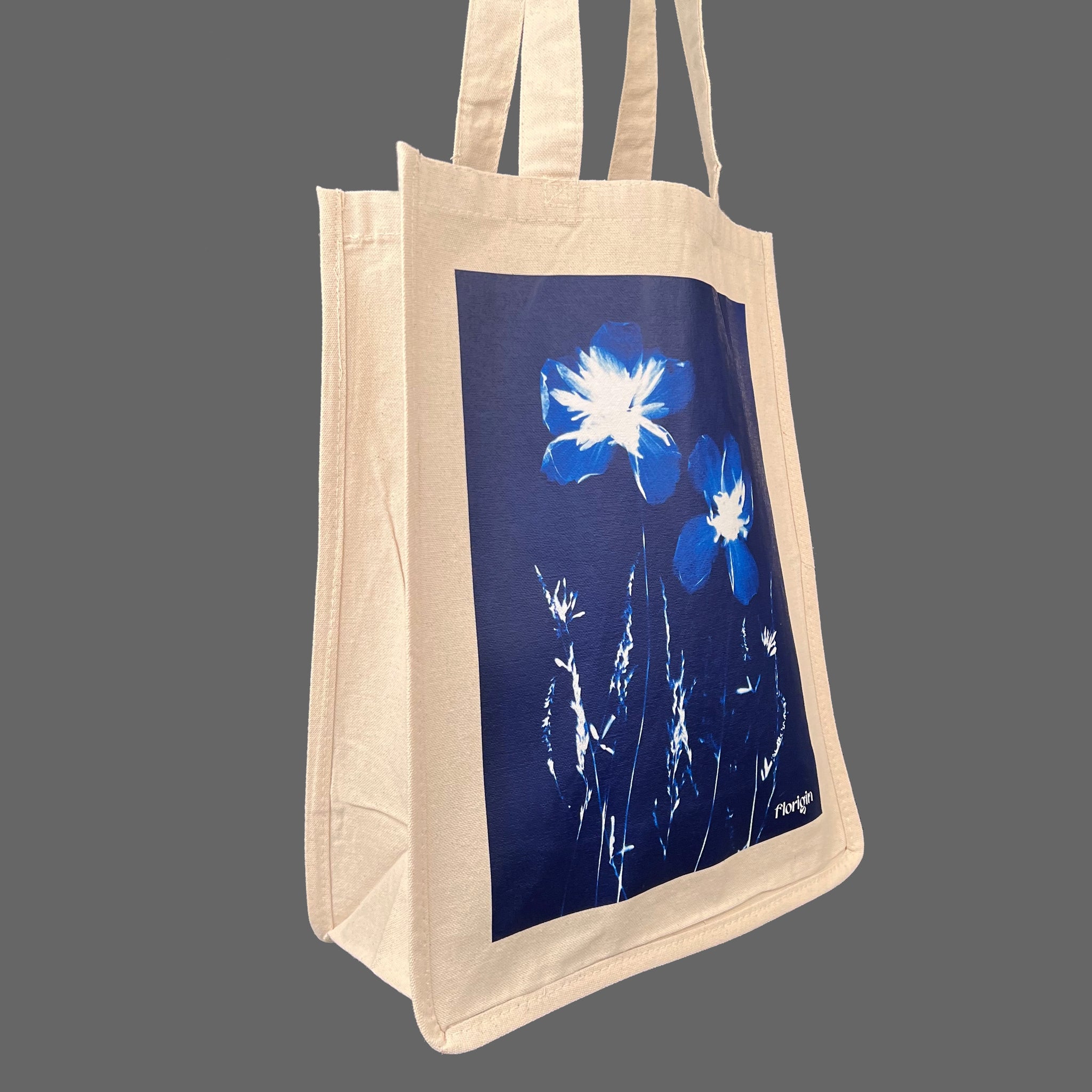 Canvas Tote Shopper with white wildflowers on a blue background 